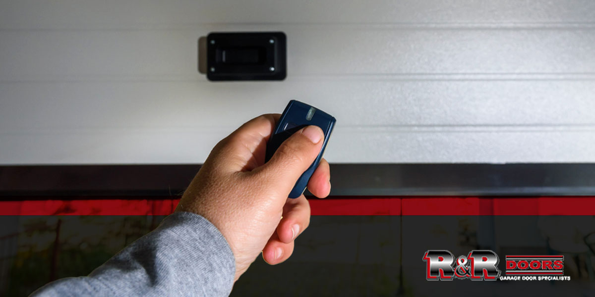 person holding garage door sensor in front of garage door